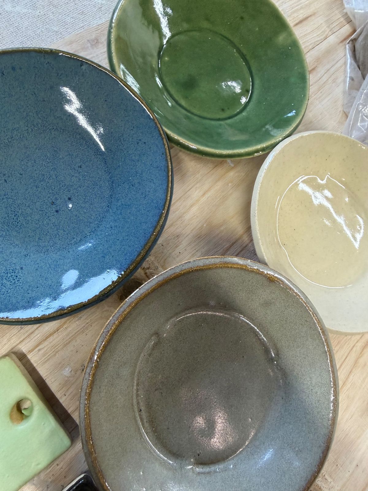 Finished glazed bowls in blue, green, cream, and gray