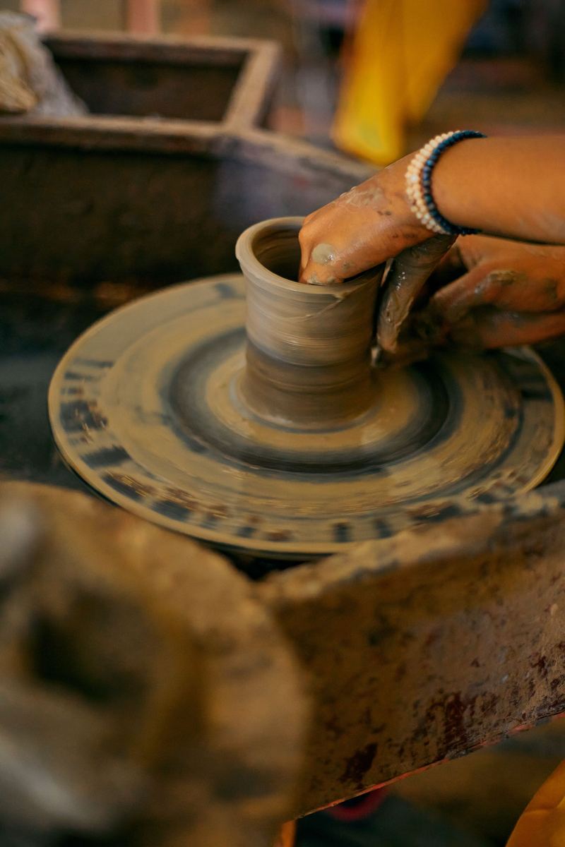 Throwing a clay cylinder on the pottery wheel